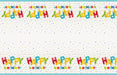Colorful plastic tablecover featuring repeating "Happy Birthday" text in balloon letter designs and scattered confetti stars on a white background.