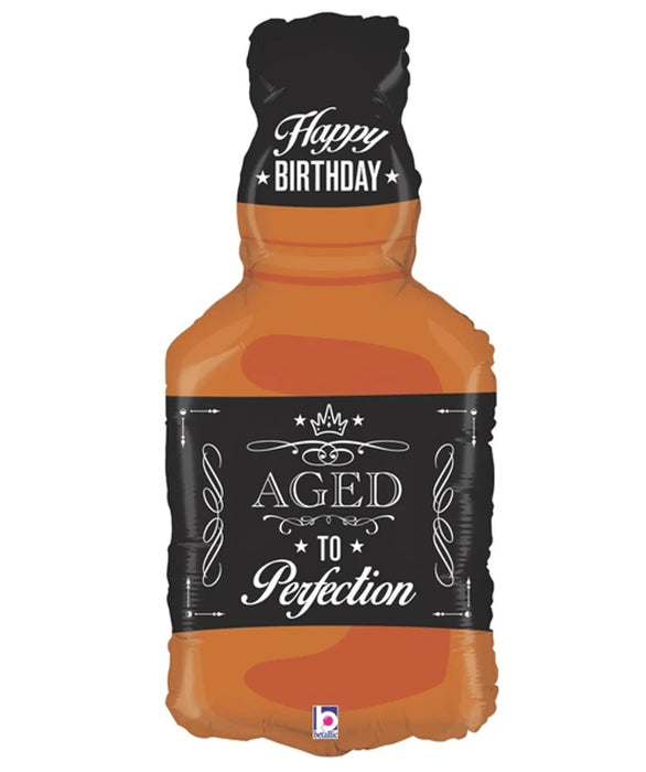 Whisky bottle-shaped foil balloon in amber and black with "Happy Birthday" text at top and "Aged to Perfection" label with crown design on the body.