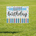 Colorful Happy Birthday yard sign featuring a blue banner, black text, multicolored polka dots, and twelve striped birthday candles with flames, mounted on a metal stake.
