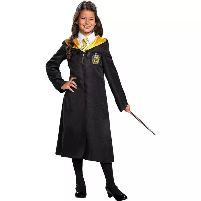 Child wearing a black wizard robe with yellow lining and a Hufflepuff crest, white shirt, yellow striped tie, and holding a wand.