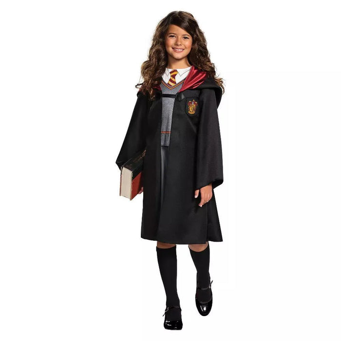 Young girl wearing a black wizard's robe with red and gold lining over a gray sweater and striped tie, holding a spellbook, black socks and shoes.
