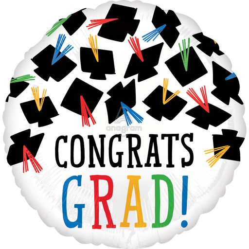 White round mylar balloon printed with black graduation caps arranged in a circle, colorful tassels in red, blue, yellow, and green, and large multicolored text reading "CONGRATS GRAD!" with an exclamation point.