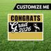 Graduation-themed sign with 'Congrats Grad 2026' on a grass background