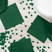 Hunter green paper napkins and coordinating party supplies arranged on a white wooden surface with scattered dark green circle confetti.