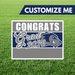 Graduation-themed sign with 'Congrats Grad 2026' on a grass background