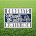White yard sign with gray and navy blue stripes featuring "CONGRATS Grad 2026 HUNTER HIGH" text and a blue cougar mascot head on green grass.