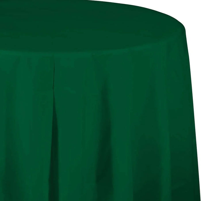 Hunter green round plastic tablecloth with gathered folds, shown draped over a table with a curved top edge visible against a white background.