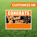 Graduation-themed sign with 'Congrats Grad 2026' on a grass background