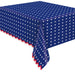 Patriotic paper tablecover with navy blue background, white star pattern, and red scalloped border on a table.