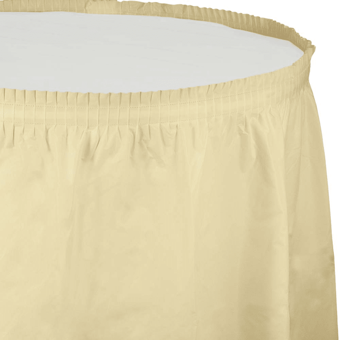 Ivory plastic tableskirt with pleated waistband and elastic gathered top edge, shown partially rolled against white background.