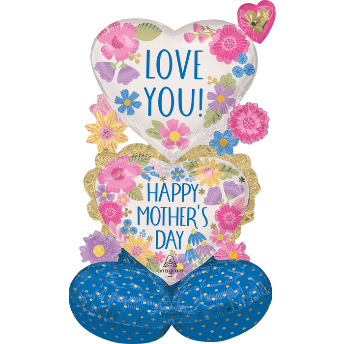 Heart-shaped mylar balloon decorated with colorful pink, purple, and blue flowers and the text "Love You" above a gold-trimmed section reading "Happy Mother's Day" with a blue polka-dotted base section.