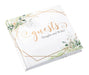 White hardcover guest book with peach script text reading "Guests" and "Thoughts and Wishes," framed by geometric gold diamond shapes and watercolor botanical illustrations in green and peach tones.