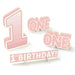 Pink three-dimensional cardstock decorations including a large numeral 1, "ONE ONE" text with stars, and "1ST BIRTHDAY!" banner for first birthday celebrations.