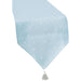 Light blue table runner with white stars and dots pattern, featuring a tassel detail at the bottom corner.