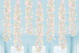 Seven iridescent spiral hanging decorations with pastel pink, yellow, and blue swirls suspended from a light blue ceiling in a bright room.