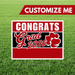 Graduation-themed sign with 'Congrats Grad 2026' on a grass background