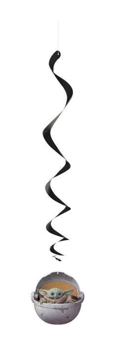 Three black spiral hanging swirl decorations suspended above a small character figure in a pod-shaped container.
