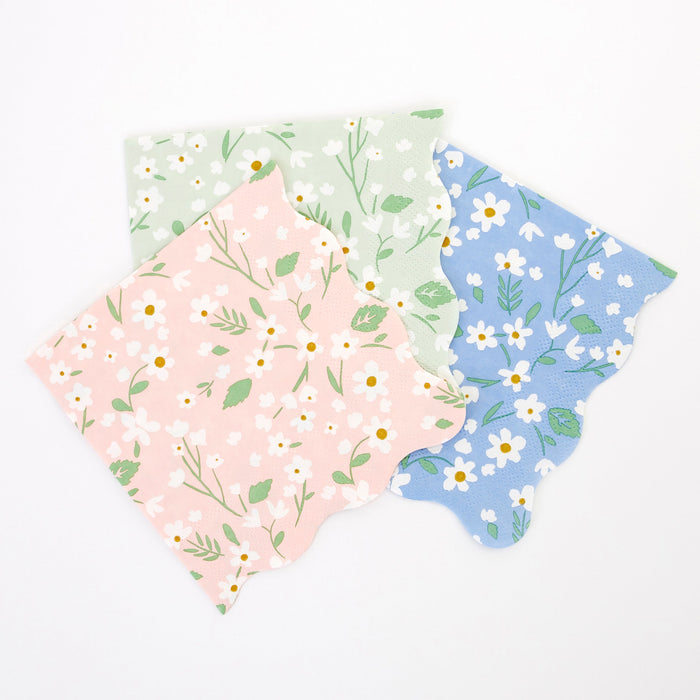Ditsy Daisy Large Napkins in pastel pink, mint, and blue with white daisy prints, green leaves, and scalloped edges on a white background.