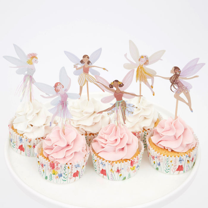 Fairy cupcake kit with pastel fairy toppers, shiny skirt accents, and floral cupcake liners displayed on frosted cupcakes.