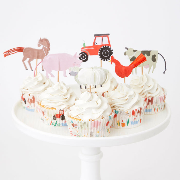On The Farm Cupcake Kit with frosted cupcakes decorated with farm animal and tractor toppers on a white cake stand.