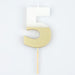 White number 5 cake candle with metallic gold dipped finish and wooden pick on a white background.
