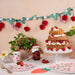 Strawberry Garland with red and pink honeycomb strawberries, green leaves, and white flower accents hanging above a strawberry-themed party table.
