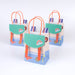 Outdoor Adventures Backpack Party Bags with teal flaps, orange handles, rainbow patches, and explorer-themed graphics on a white background.