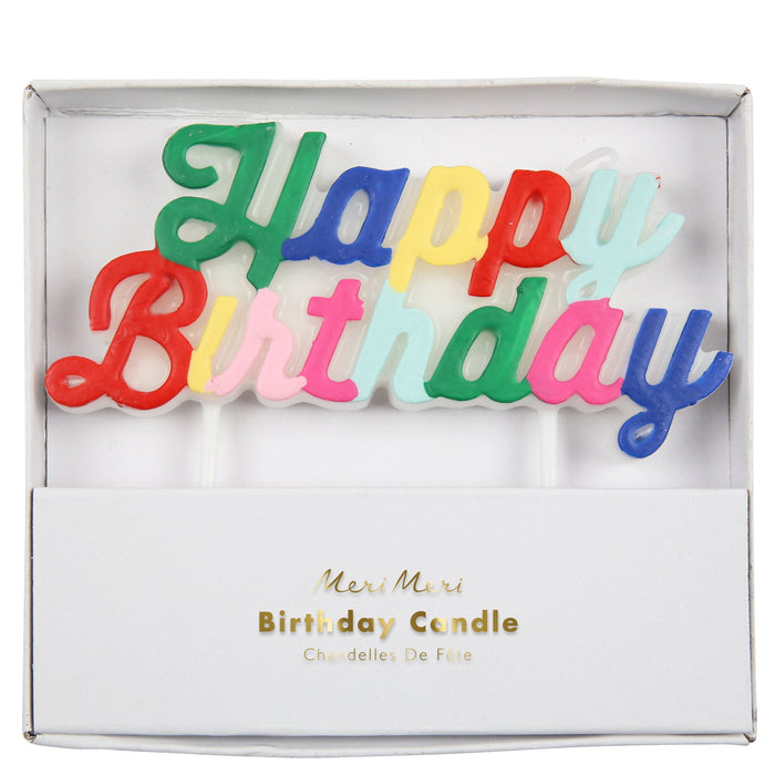 Multicolor Happy Birthday Candle in white packaging with colorful script lettering mounted on clear cake picks.