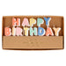 Happy Birthday candle set with pastel letter candles spelling “Happy Birthday” in kraft display packaging.