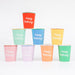 Mixed Happy Birthday paper cups in assorted bright and pastel colors with white birthday lettering.