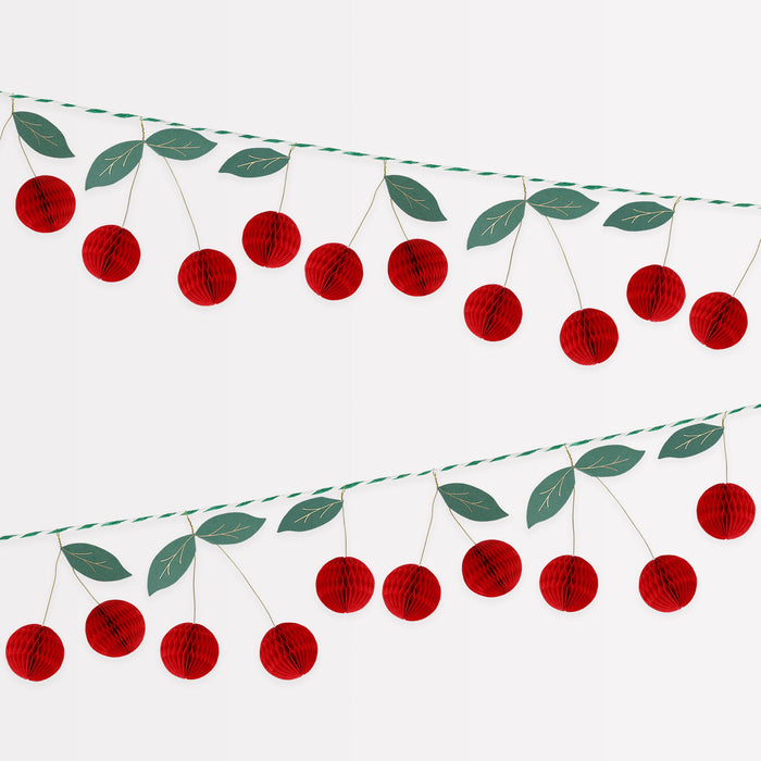 Cherry honeycomb garland with red honeycomb cherries, green paper leaves, and hanging twine.