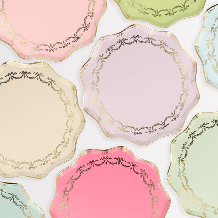 Ladurée Paris Side Plates in assorted pastel colors with wavy edges, metallic gold trim, and delicate gold garland details.

