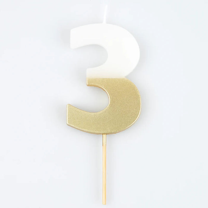 White number 3 cake candle with metallic gold dipped finish and wooden pick on a white background.