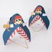 Blue Pirate Party Hats with navy pirate hat shape, red-and-white striped interior, skull and crossbones design, gold sword accent, and elastic cords on a white background