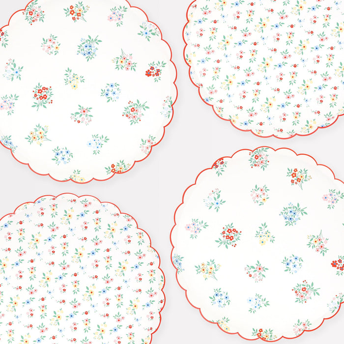 Ditsy Posy Scalloped Dinner Plates with white background, tiny multicolor floral prints, green leaves, and red scalloped edges.