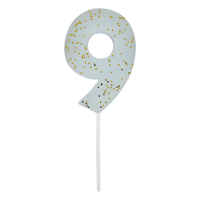 Pale blue number 9 cake candle with gold speckle accents and white pick on a white background.