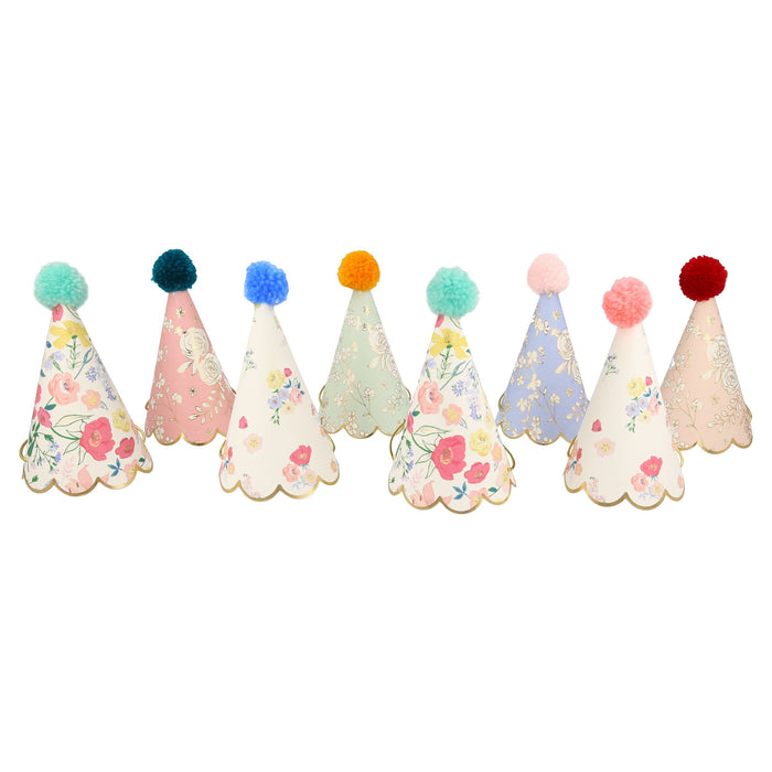 English Garden Party Hats arranged on a white background with assorted floral cone hats, scalloped gold trim, and colorful pompom toppers.