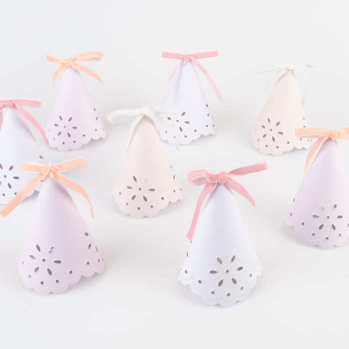 Broderie Anglaise party hats in pastel colors with scalloped edges, floral cutouts, and ribbon bows.