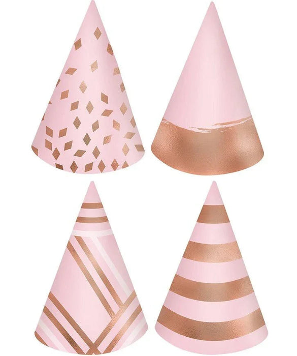 Four pink cone party hats with rose gold metallic accents featuring diamond patterns, solid bands, and diagonal stripes.