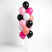 Vertical arrangement of 12 latex balloons in black, hot pink, light pink, white, and coral, tied together with clear strings against a white background.