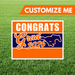 Graduation-themed sign with 'Congrats Grad 2026' on a grass background
