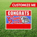 Graduation-themed sign with bulldog graphic and 'Congrats Grad 2026' text on a grass background