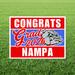 Red, white, and blue yard sign with "Congrats Grad 2026 Nampa" text and a bulldog mascot head in the center, displayed on grass.