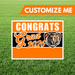 Graduation-themed sign with tiger design on grass