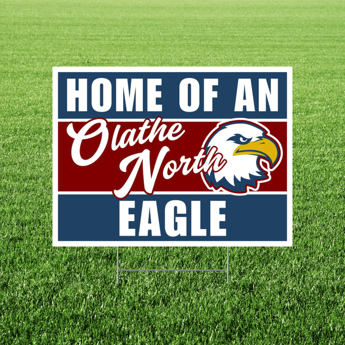 Rectangular yard sign with navy blue and burgundy stripes featuring white text reading "HOME OF AN Olathe North EAGLE" alongside an eagle head logo in navy, white, and gold.