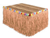 Rectangular table skirt with tan grass fringe trim and multicolored flower garland along the top edge.