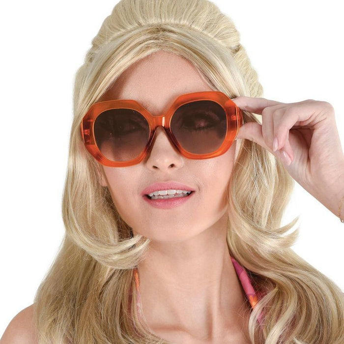 Oversized round sunglasses with bright orange frames and dark amber-tinted lenses, displayed on a model with blonde hair.