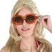 Oversized round sunglasses with bright orange frames and dark amber-tinted lenses, displayed on a model with blonde hair.
