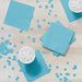 Stack of turquoise paper napkins with white bowls of ice and scattered turquoise confetti dots on a light wood surface.