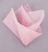 Crumpled sheets of soft pastel pink tissue paper layered and arranged against a gray background.